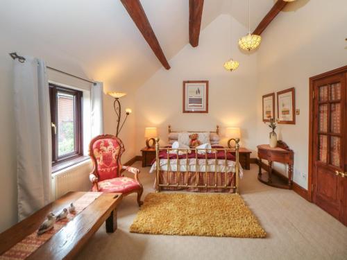 a bedroom with a bed and a chair and a table at The Haybarn in Lichfield