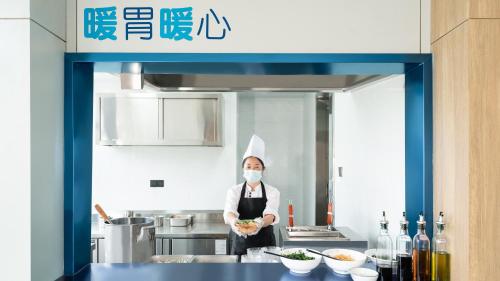 Un chef en una cocina con una mascarilla en Holiday Inn Express Kunming Panlong by IHG, en Kunming