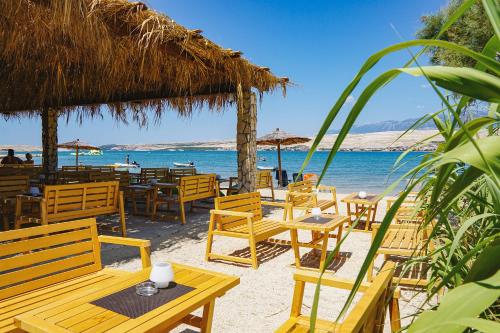 un grupo de mesas y sillas en la playa en Terra Park SpiritoS en Kolan