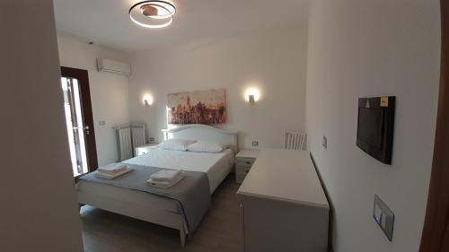 a bedroom with a bed and a desk and a television at Villa Saponaro - Affittacamere in Torre Lapillo