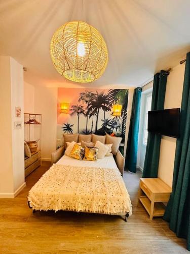 une chambre avec un grand lit et un lustre dans l'établissement Les Appartements de Nana 2 - T2 Hypercentre, Rue Meynadier, Palais & Plage, clim, wifi, à Cannes