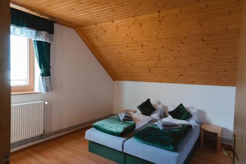 - un salon avec un canapé et des oreillers verts dans l'établissement Jambrichova chata, à Vysoké Tatry