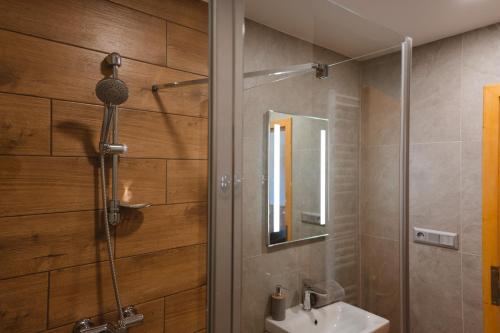 a bathroom with a shower and a sink and a mirror at Jambrichova chata in Vysoké Tatry