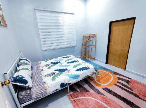 a bedroom with a bed with a blue wall at DLuna Homestay Terengganu in Kuala Terengganu