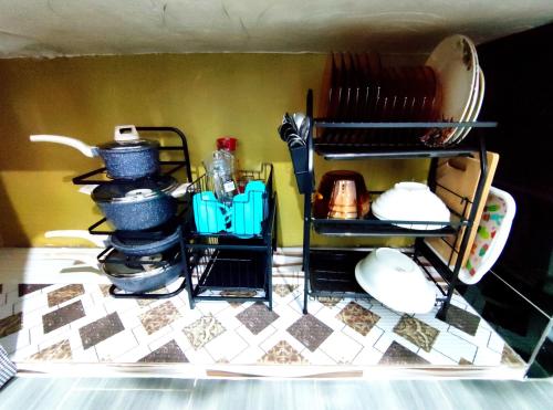 a kitchen counter with plates and utensils at DLuna Homestay Terengganu in Kuala Terengganu
