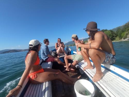 a group of people sitting on a boat on the water at Sunset Lake hostel in Ohrid