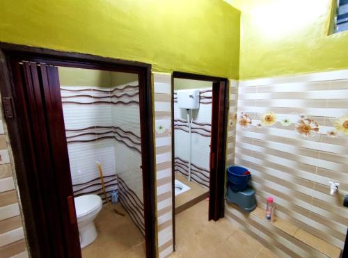 a bathroom with a toilet and two mirrors at DLuna Homestay Terengganu in Kuala Terengganu