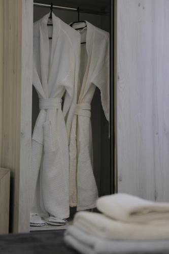 two white dresses are hanging in a closet at OXYGEN Shekvetili in Shekvetili