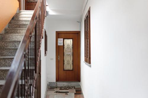 a hallway with stairs and a wooden door at Casa Vacanza Malva in Baveno