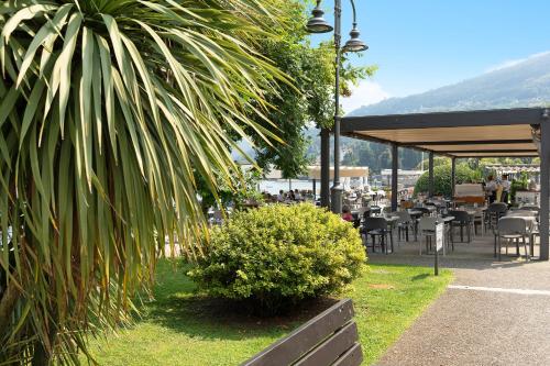a park with a bench and tables and chairs at Casa Vacanza Malva in Baveno