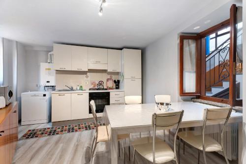 a kitchen with a white table and chairs in a room at Casa Vacanza Malva in Baveno