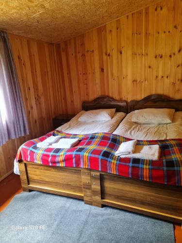 Bett in einem Zimmer mit Holzwänden in der Unterkunft LIO in Glola