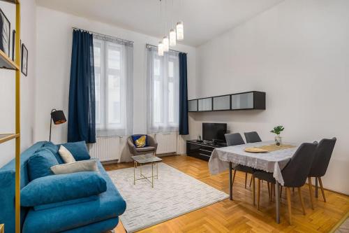a living room with a blue couch and a table at Venus Apartments - Gozsdu court III in Budapest
