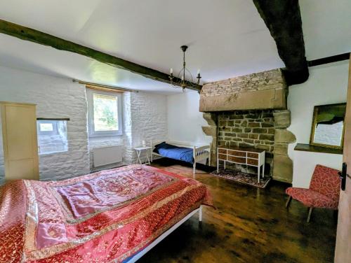- une chambre avec un lit et une cheminée en pierre dans l'établissement Les Gites de la Cabache, à Montaigu-les-Bois