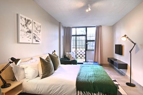 a bedroom with a large bed and a large window at Circa Aparthotel by Totalstay in Pretoria