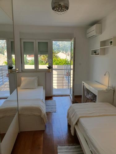 a bedroom with two beds and a balcony at Apartment NINA in Rab