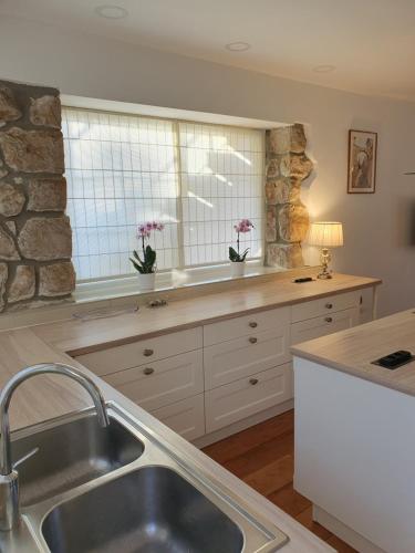 a kitchen with a sink and a stone wall at Apartment NINA in Rab