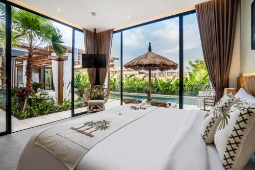 - une chambre avec un grand lit et de grandes fenêtres dans l'établissement Villa Sawadee by BaliSuperHost, à Canggu