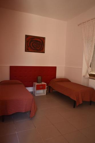 a hotel room with two beds and a table at Ostello Salento in Alezio
