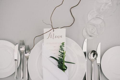 a table with a white plate with a menu on it at Mövenpick Hotel Sukhumvit 15 Bangkok in Bangkok