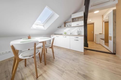 a kitchen and dining room with a white table and chairs at GUDU apartments in Košice