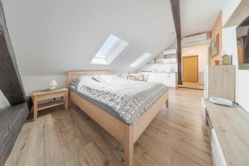 a bedroom with a bed and a wooden floor at GUDU apartments in Košice