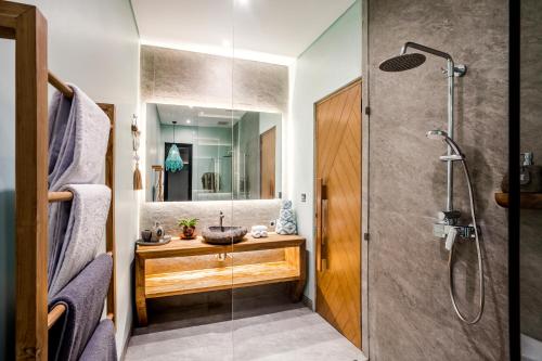 La salle de bains est pourvue d'un lavabo et d'une douche. dans l'établissement Villa Sawadee by BaliSuperHost, à Canggu