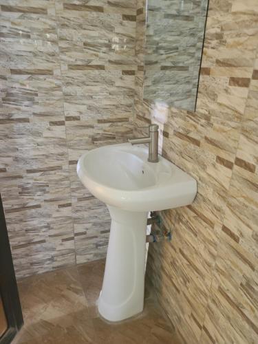 a bathroom with a white sink and a mirror at Peacefully Resort in Dodoma