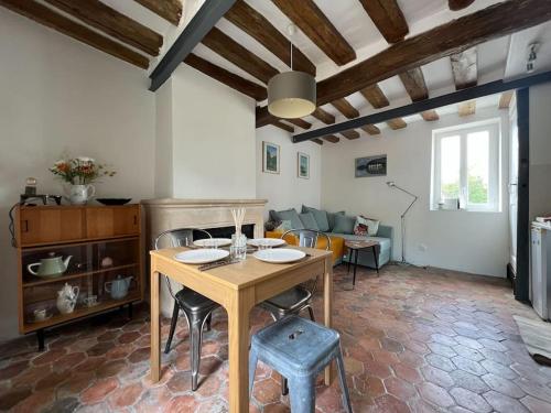 un salon avec une table et des chaises en bois dans l'établissement Maison privée - Centre Montigny, à Montigny-sur-Loing