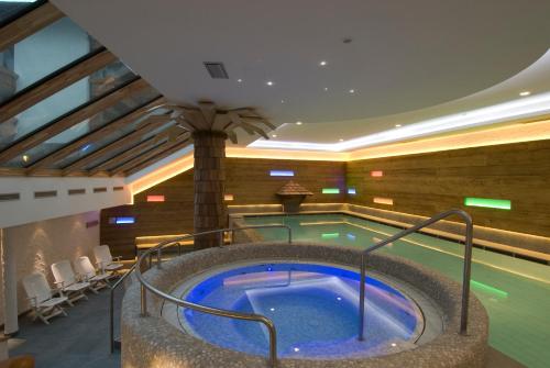 una piscina con bañera de hidromasaje en una habitación de hotel en Hotel Orsingher, en San Martino di Castrozza