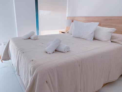 a large white bed with towels on top of it at Exclusivo Ático de Lujo en la Playa - holaVivienda Inmobiliaria in Denia