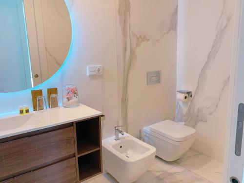 a bathroom with a toilet and a sink and a mirror at Exclusivo Ático de Lujo en la Playa - holaVivienda Inmobiliaria in Denia