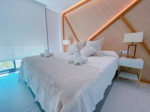 een slaapkamer met een groot wit bed en een raam bij Apartamento exclusivo en la playa in Denia