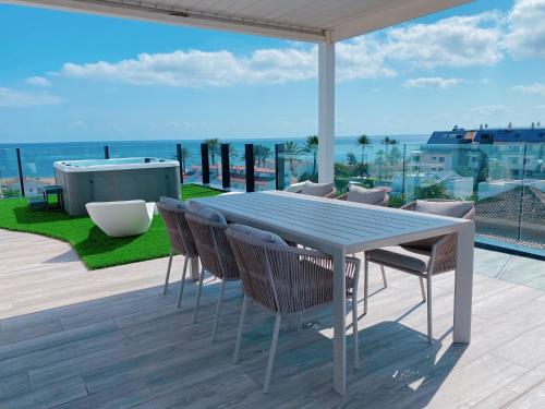 a table and chairs on a patio with a view of the ocean at Exclusivo Ático de Lujo en la Playa - holaVivienda Inmobiliaria in Denia