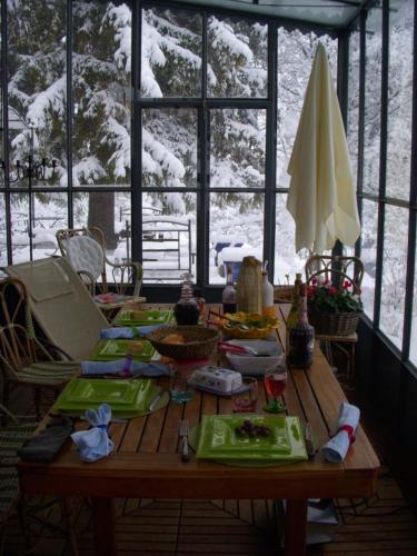- une table en bois dans une chambre avec de la neige à l'extérieur dans l'établissement La Becassiere, à Thorenc