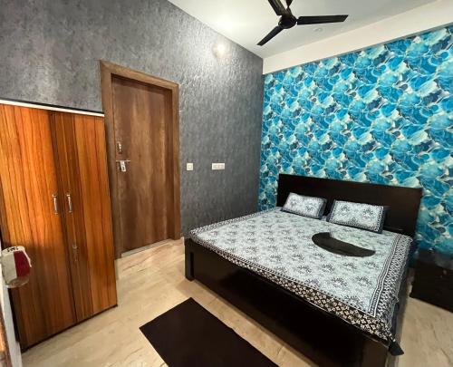 a bedroom with a bed with a blue wall at Prabhu Sadan home stay in Govardhan