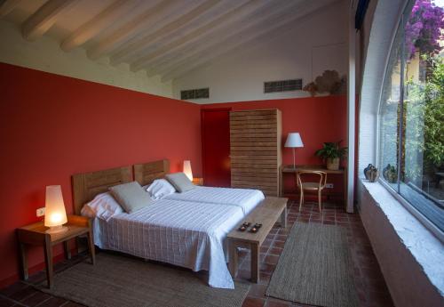 1 dormitorio con 1 cama en una pared roja en Hotel Canaleta Heras en Espolla