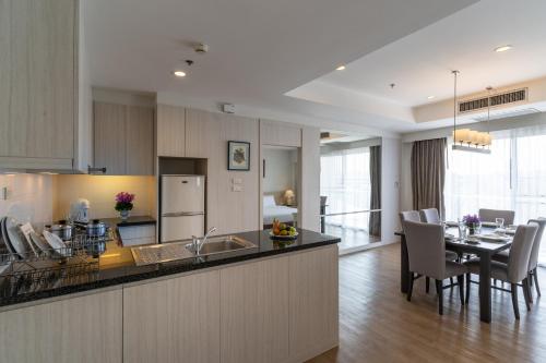 a kitchen and dining room with a table and chairs at Classic Kameo Hotel and Serviced Apartments, Sriracha in Si Racha