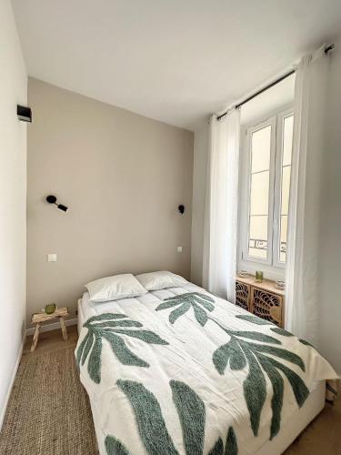 - une chambre dotée d'un lit avec une couverture verte et blanche dans l'établissement Lamartine hypercentre 112, à Nice