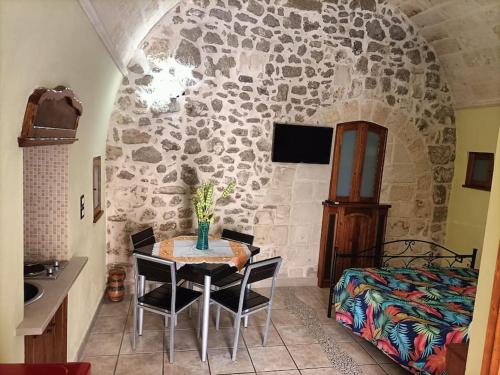a kitchen with a table in a room with a stone wall at Il nido delle aquile in Oria