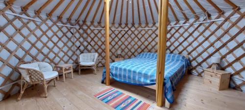 ein Schlafzimmer in einer Jurte mit einem Bett und Stühlen in der Unterkunft Agriturismo Poggio Ferrata in Ruvo di Puglia