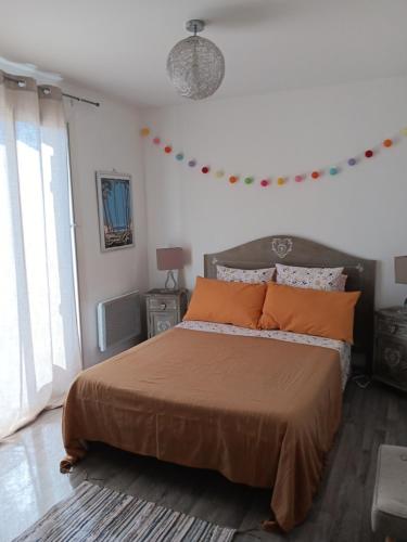 a bedroom with a large bed with orange pillows at Chez kary in Saint-Cyr-sur-Mer