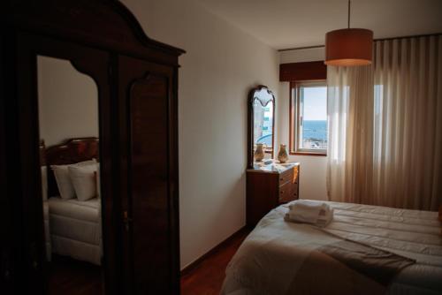 1 dormitorio con cama, espejo y ventana en Apartamento T3 Vista Mar - Anzol en Vila do Conde