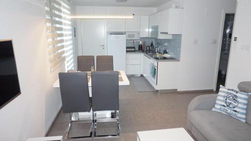 uma cozinha e sala de estar com mesa e cadeiras em Mandy Apartman em Baska