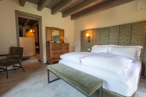 a bedroom with a large white bed and a chair at Ca' Barroni Agriresort in Sondrio