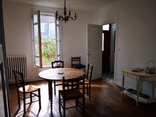 d'une salle à manger avec une table, des chaises et une fenêtre. dans l'établissement Le Polygone, au Mans