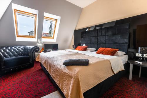 a bedroom with a large bed and a black leather chair at Lovely 4-bedroom flat in historical center with stunning view in Trenčín