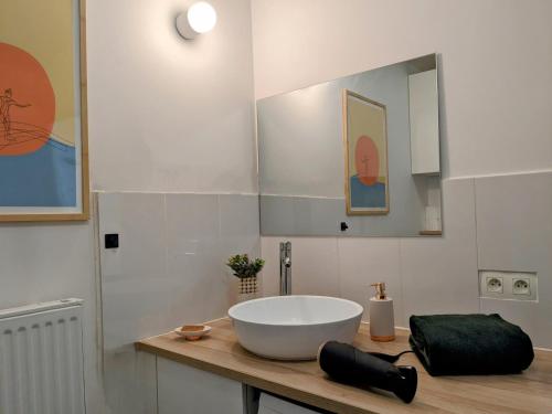 La salle de bains est pourvue d'un grand lavabo blanc sur un comptoir. dans l'établissement La Terrasse du tramway, Parking, 30min de Paris, à Bezons