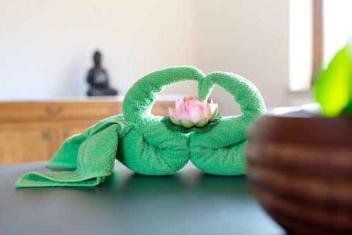 a green towel with a pink flower in it at Haus Erika Ferienwohnung 1 in Bad Teinach-Zavelstein