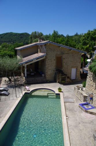 une grande piscine en face d'une maison dans l'établissement LES CHAISES LONGUES, à Peyrins